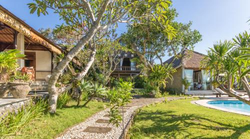 a house with a swimming pool and a yard at Casa Jimbaran Villa in Jimbaran