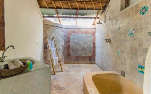 a bathroom with a sink and a bath tub at Casa Jimbaran Villa in Jimbaran