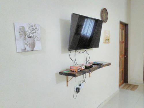 telewizor z płaskim ekranem wiszący na ścianie w obiekcie Homestay Pulau Langkawi w mieście Pantai Cenang