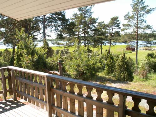 a porch with a view of a field and trees at Söderö Stugby in Finström