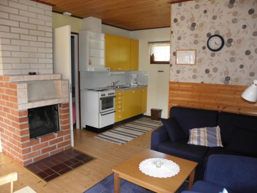 a living room with a blue couch and a fireplace at Söderö Stugby in Finström
