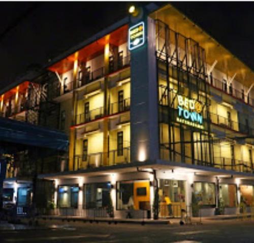 a building with a sign on the side of it at night at Bed@Town Hostel in Bangkok