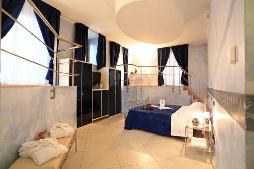 a bedroom with a blue bed and some windows at Hotel L'Aquila in LʼAquila