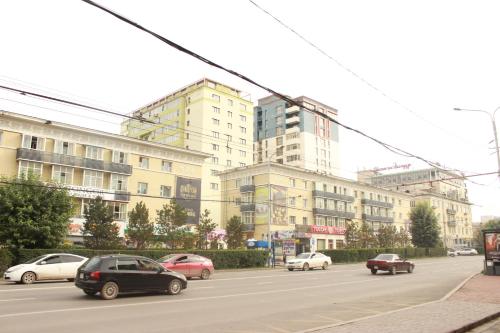 a street with cars parked in front of a building at Khongor Guest house & Tours in Ulaanbaatar
