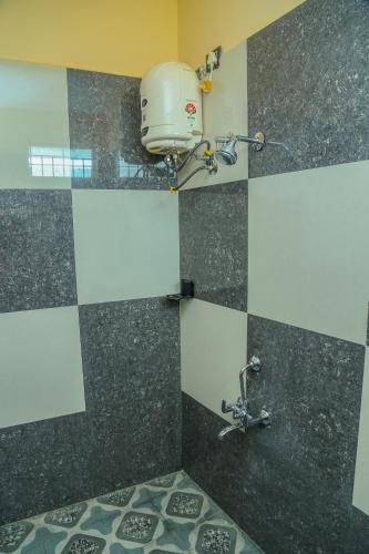 a bathroom with a sink and a shower with a bucket at P A Resort in Yelagiri