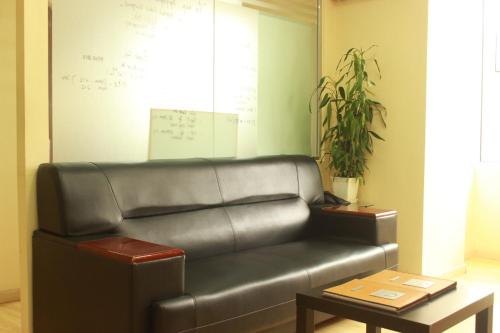 a leather couch in a room with a table at Khongor Guest house & Tours in Ulaanbaatar