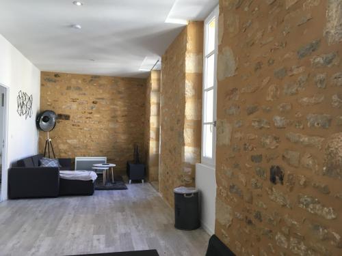 a living room with a brick wall at Les lumières de Sarlat in Sarlat-la-Canéda