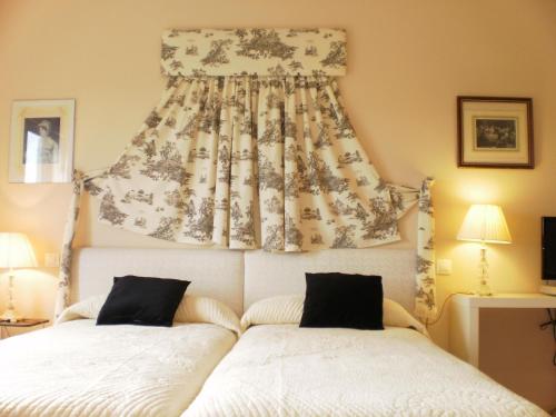 a bedroom with two beds and a curtain on the wall at Hotel Santa Coloma del Camino in Olmillos de Sasamón