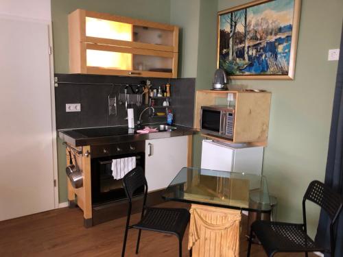 eine Küche mit einem Glastisch und einer Mikrowelle in der Unterkunft Gästewohnung im Logenhaus in Mainz