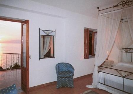 a room with a bed and a chair and a window at Hotel Club San Diego in Maratea