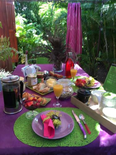 a purple table topped with plates of food and drinks at Le Chalet dAZAE in La Rivière