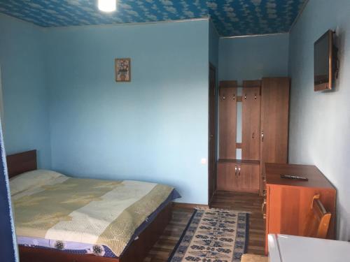 a bedroom with a bed and a wooden cabinet at AltynAi Guest House in Cholpon-Ata