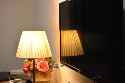 a lamp with a vase of flowers next to a mirror at YoYo Youth Apartment in Guangzhou