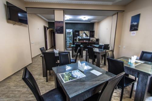 a restaurant with tables and chairs and a piano at Hotel Svanseti in Mestia