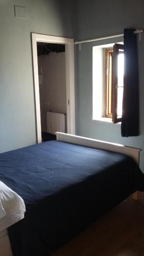 a bedroom with a blue bed with a window at La Ripa in Rocca San Felice