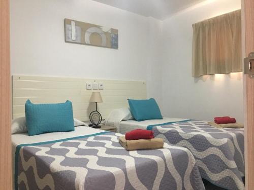 two beds in a room with blue and white at Apartamento con Vistas al Mar in Playa del Ingles
