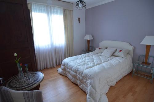 a bedroom with a white bed and a table at Domaine de Lazuel à 2,5km du centre ville in Aubenas