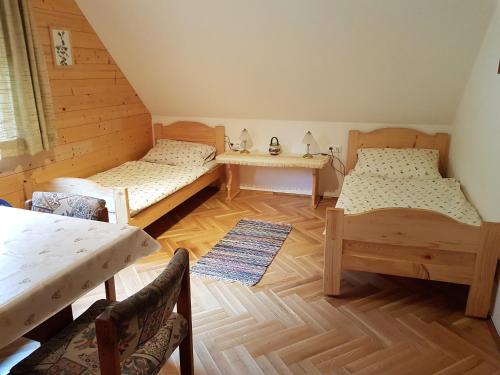 a room with two beds and a table and chairs at Schweighofers Almhaus in Heilbrunn