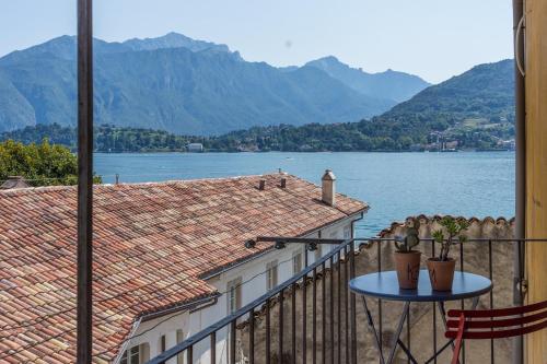 
a patio area with a balcony and a boat on the water at Casa Aquadulza in Tremezzo
