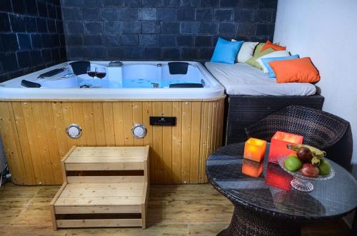 a room with a hot tub and a table with a bowl of fruit at Luna Bianca in Had Nes