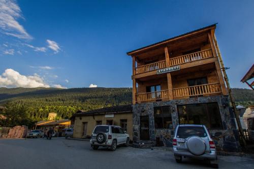 a building with cars parked in front of it at Hotel Svanseti in Mestia