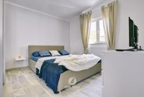 una camera con un letto e una televisione di Villa Emily a Peroj