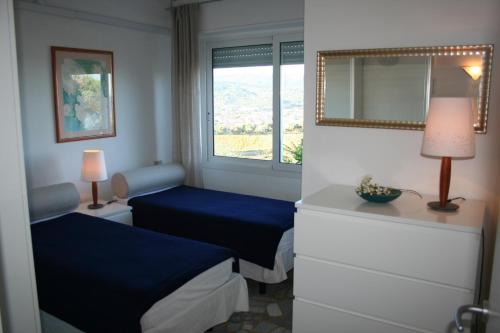 a bedroom with two beds and a mirror and a window at Villa Panorama in Diano Marina