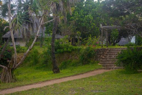 a stairway leading up to a house with a tree at Amani Beach Resort in Kutani