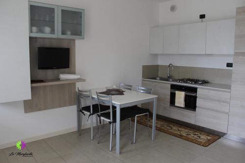 a kitchen with a table and chairs and a sink at Residence La Margherita in Lazise