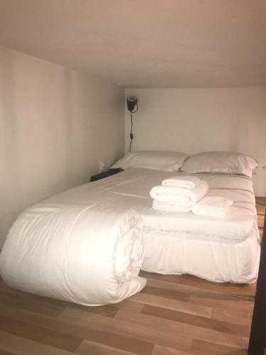 パリにあるParisian cosy flatの白いベッド(白いシーツ、枕付)