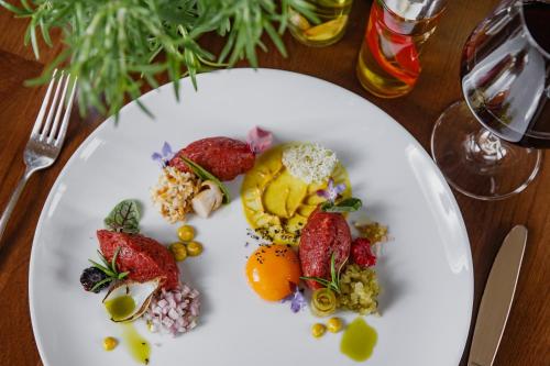 a white plate with fruit and vegetables on a table at Hotel Dwór Choiny in Kazimierzówka