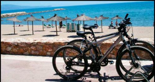 a bike parked next to a beach with umbrellas at Sea view house on Poros in Poros