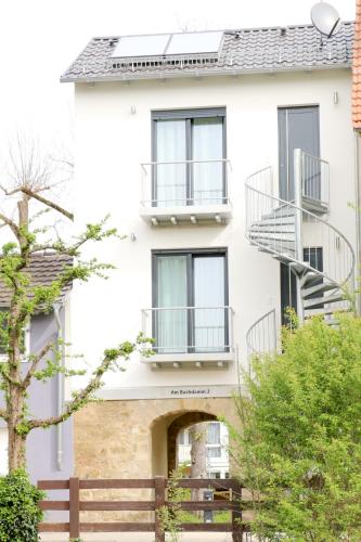 a white building with windows and a fence at Alte Stadtmauer - Apartment in Sinsheim