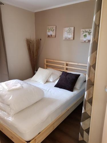 une chambre avec un lit avec des draps blancs et des oreillers dans l'établissement Marina village, à Saint Cyprien Plage