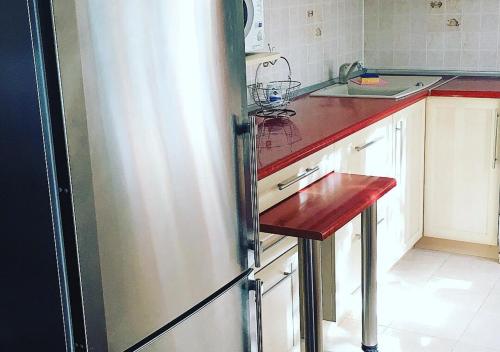 eine Küche mit einem Kühlschrank und einer Holzoberfläche in der Unterkunft Apartment in city center in Kiew
