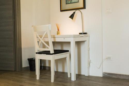 a white desk with a chair and a lamp at Country Resort Modena in Modena