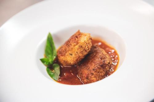 a white bowl of food with meatballs and sauce at Hotel Venezia New in Vasto