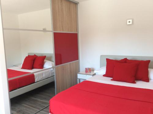 a hotel room with two beds with red pillows at Number9 Studio - Now with air conditioning in Carlipa