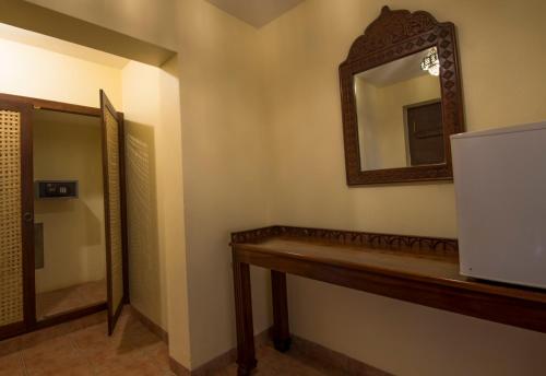 a bathroom with a mirror on the wall and a counter at Amani Beach Resort in Kutani