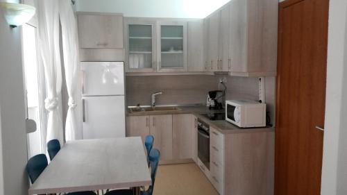 a small kitchen with a table and a white refrigerator at Polichrono in Polykhrono