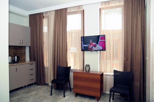 a room with a tv on a window with two chairs at Nimako's Apartment in Borjomi