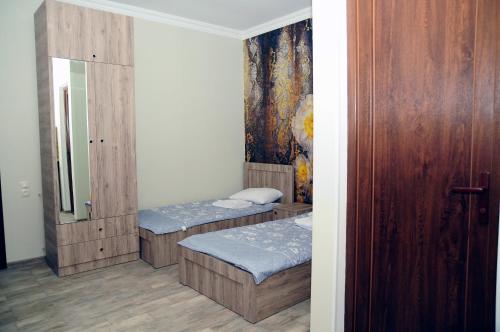 a room with two beds and a mirror at Nimako's Apartment in Borjomi