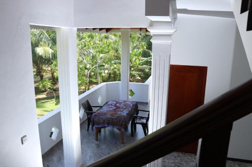 una stanza con un tavolo, delle sedie e una finestra di Villa Sureka a Hikkaduwa