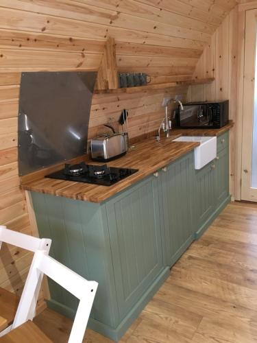 a kitchen with a stove and a counter top at Cil y Coed Luxury Pod in Machynlleth
