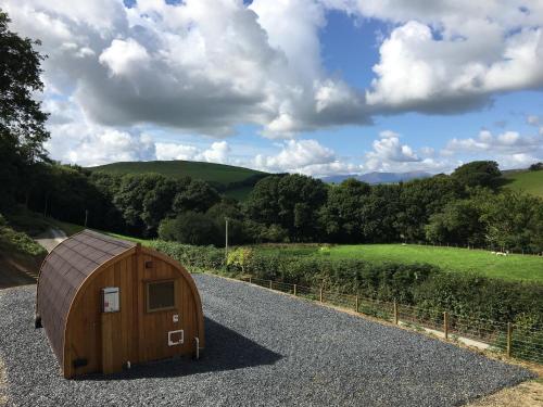 a wooden hobbit house on the side of a road at Cil y Coed Luxury Pod in Machynlleth