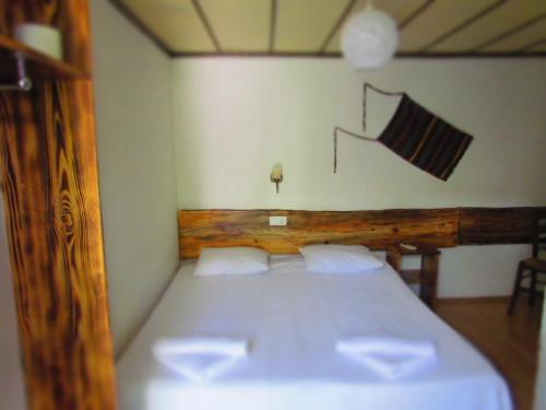 a bedroom with a white bed with a wooden headboard at Amazon Antique in Selcuk