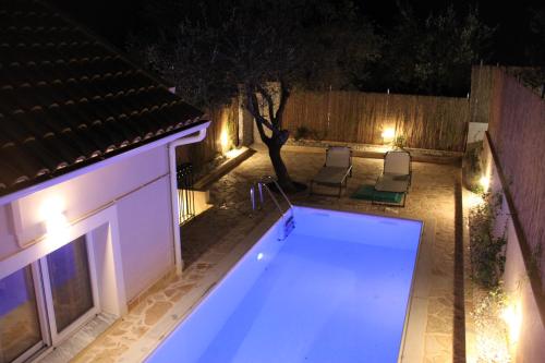 an empty swimming pool in a backyard at night at Villa Pilali in Kefallonia