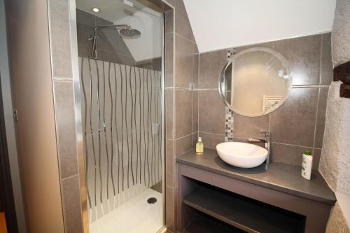 une salle de bain avec un lavabo et un miroir dans l'établissement Le Cottage Lavastrie, à Lavastrie