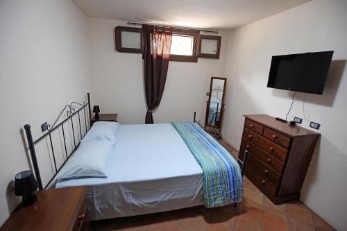 1 dormitorio con 1 cama, vestidor y TV en Casa Santina, en Girasole