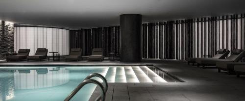 a pool in a hotel with chairs and tables at The Middle House in Shanghai